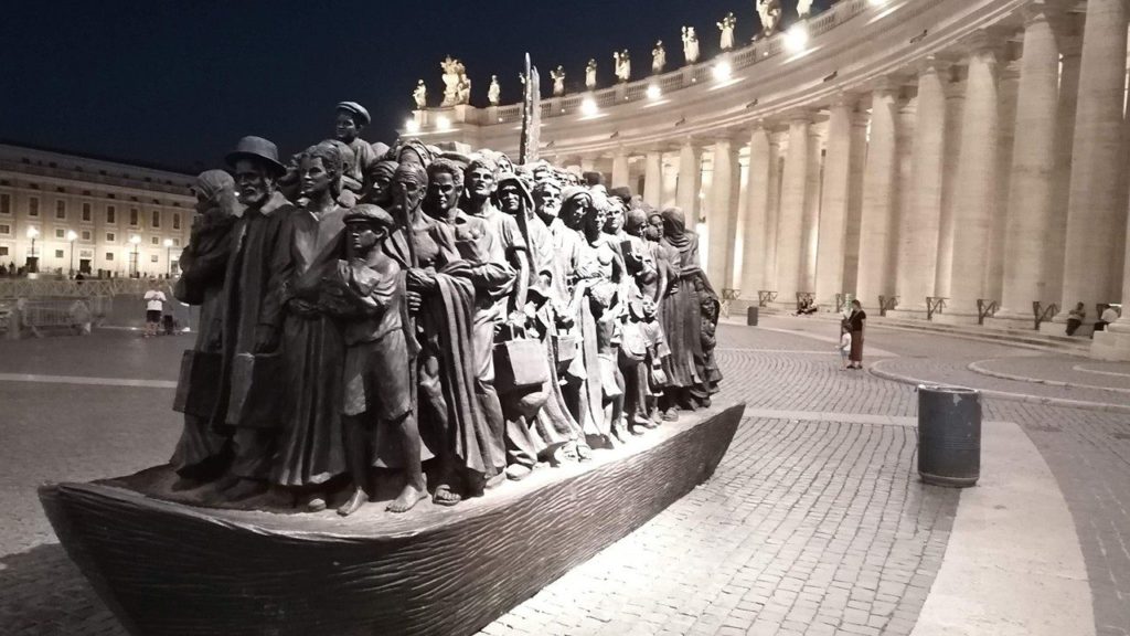 Un Qr code sulla statua dei migranti in piazza San Pietro